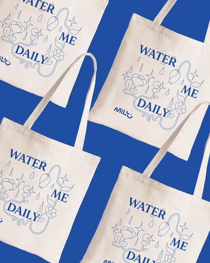 Beige MILLU tote bags with blue Water Me Daily lettering and floral illustrations arranged on a blue background.